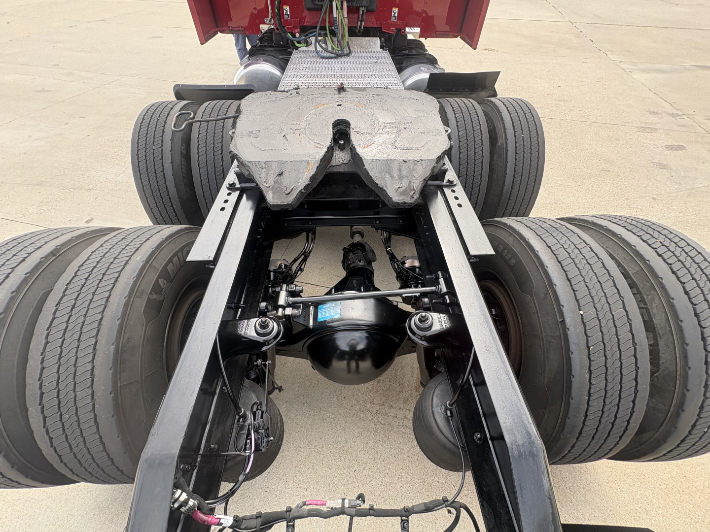 Peterbilt truck chassis view showing rear dual tandems, fifth wheel housing, air lines, and suspension components with dual rear axles.