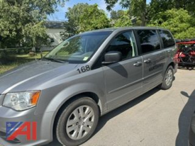 Front left-side view of a silver 2016 Dodge Grand Caravan SE minivan with black side mirrors and tinted windows.