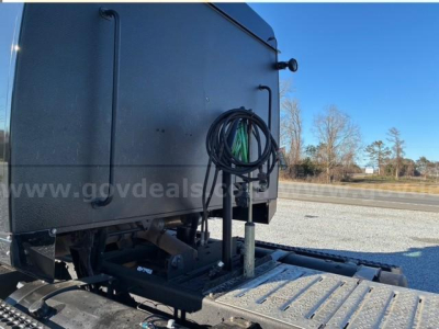 Trucks showing rear of Western Star 4900 SA with hitch and mounted cables, tail area, and metal platform viewed from side.