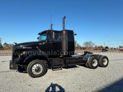 Western Star 4900 SA tractor chassis side view showing dual rear axles and black exterior.
