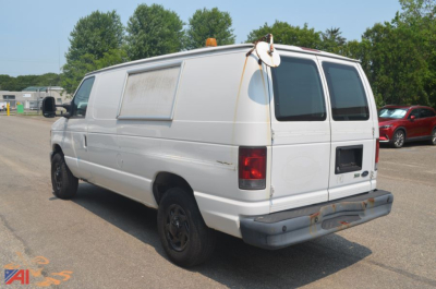 Ford E350 cargo van showing rear and passenger side with windowed cargo area and faded exterior.