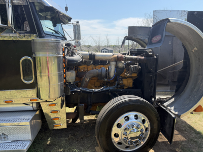 Peterbilt 379X Conventional Sleeper truck engine bay showing diesel engine and front wheel.