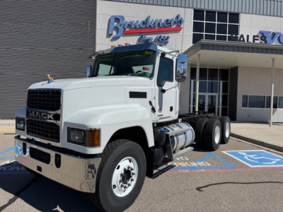 Mack PI64 dump truck in white color shown in front view with chrome bumper and dual rear axles, parked in a lot near a dealership.