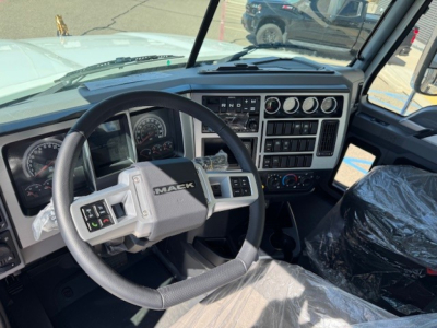 Mack PI64 truck interior showing steering wheel, dashboard gauges, gear selector, and center console controls.