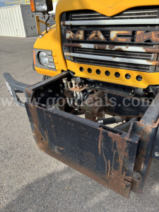 Mack CV713 front view showing bumper and grille with exposed engine area and rusted front shield.