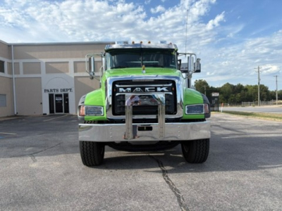 Mack GR64F front view showing bright green cab and chrome grille guard.