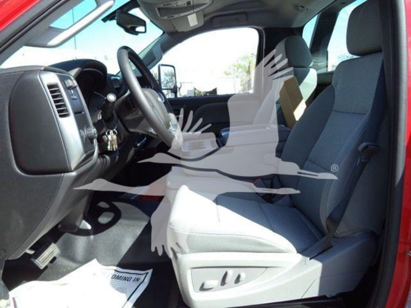 Interior of a 2023 Chevrolet Silverado 6500HD cab showing driver seat, steering wheel, and front passenger seat with gray upholstery.