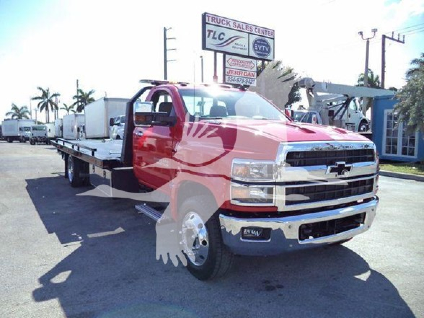 Chevrolet Silverado 6500HD rollback tow truck shown in red with flatbed and chrome bumper, side view