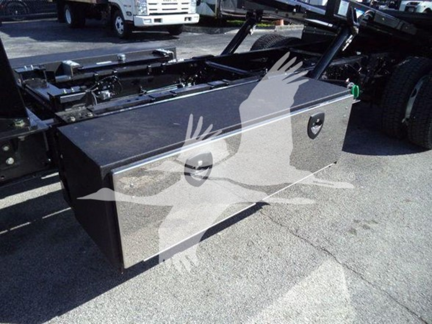 Toolbox mounted on a rollback truck chassis with two recessed handles and a locking latch visible.