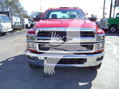Front view of a red 2023 Chevrolet Silverado 6500HD rollback truck showing chrome grille and bumper.