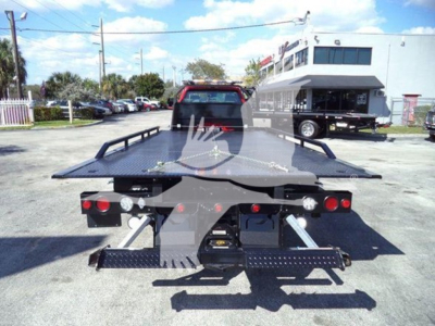Truck bed of 2023 Chevrolet Silverado 6500hd rollback showing rear view with hydraulic deck and taillights.