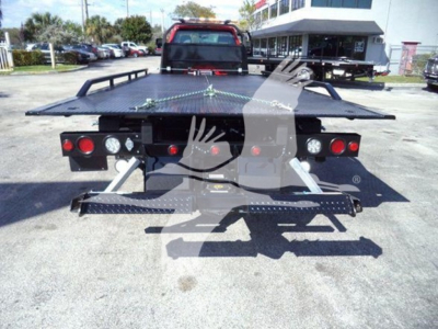 Tow truck rollback bed with rear view showing hydraulic rails and ramped platform