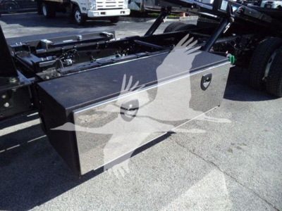 Toolbox mounted on a rollback truck chassis with two recessed handles and a locking latch visible.