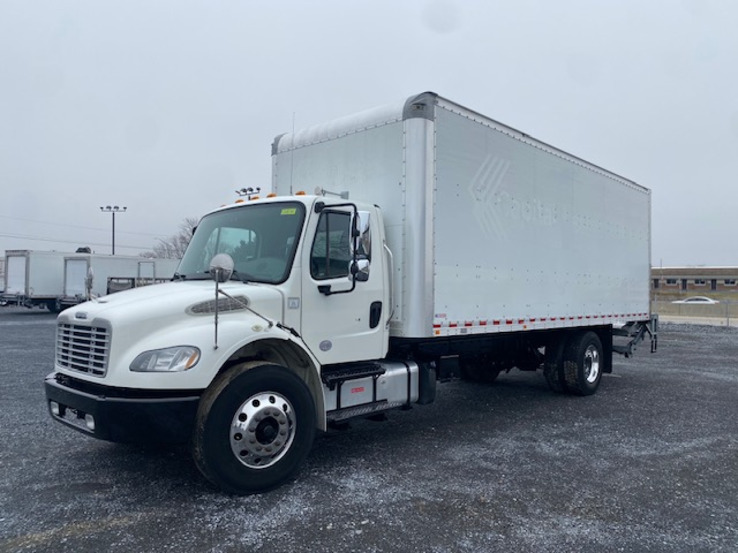 2019 Freightliner M2-106 box truck with a white cab and a large white box body. Front grille, headlights, dual rear wheels. No visible text on vehicle.