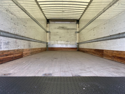 Freightliner M2-106 cargo box interior showing empty trailer with metal side rails and wood-trim lower walls.