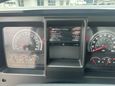 Mack GR64F instrument cluster showing digital vehicle totals display with engine hours and RPM gauges visible.