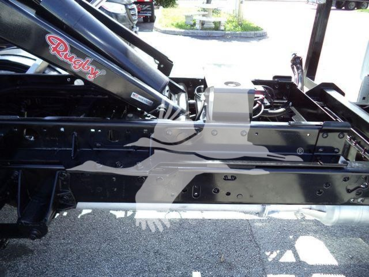 Ford F-550 rollover truck chassis with black frame and hydraulic components, showing rugged metal rails and mount points.