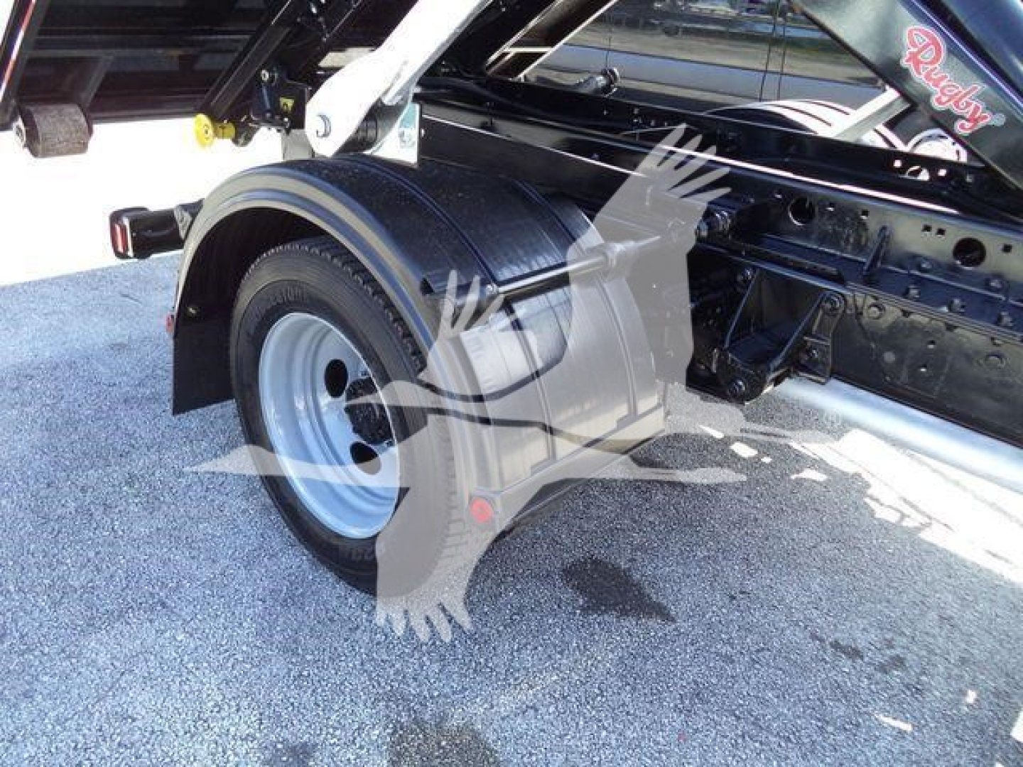 Truck chassis and rear wheel area of a 2020 Ford F550 rolloff truck showing wheel, fender, and frame components.
