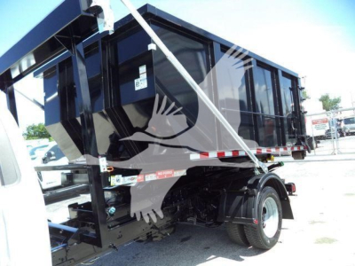 Front-left view of a black roll-off truck bed on a 2020 Ford F550 showing hydraulic components and wheel well.