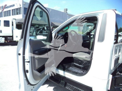 Truck cab interior with open driver's door showing front seating and doorway, 2020 Ford F550 roll-off truck.