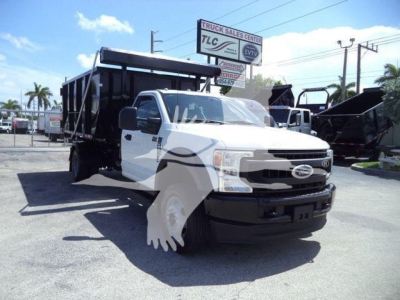 Ford F-550 dump truck in white with black dump bed, front grille and bumper, side mirrors visible.