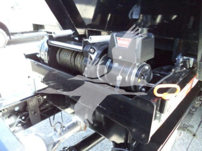 Ford F-550 roll-off truck winch system with hook and coil rope visible in the engine bay area
