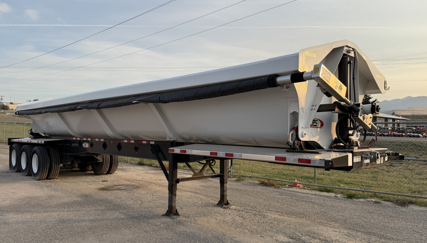 Manac 42' tri-axle dump trailer on a stand with gooseneck hitch and stacked wheels visible.