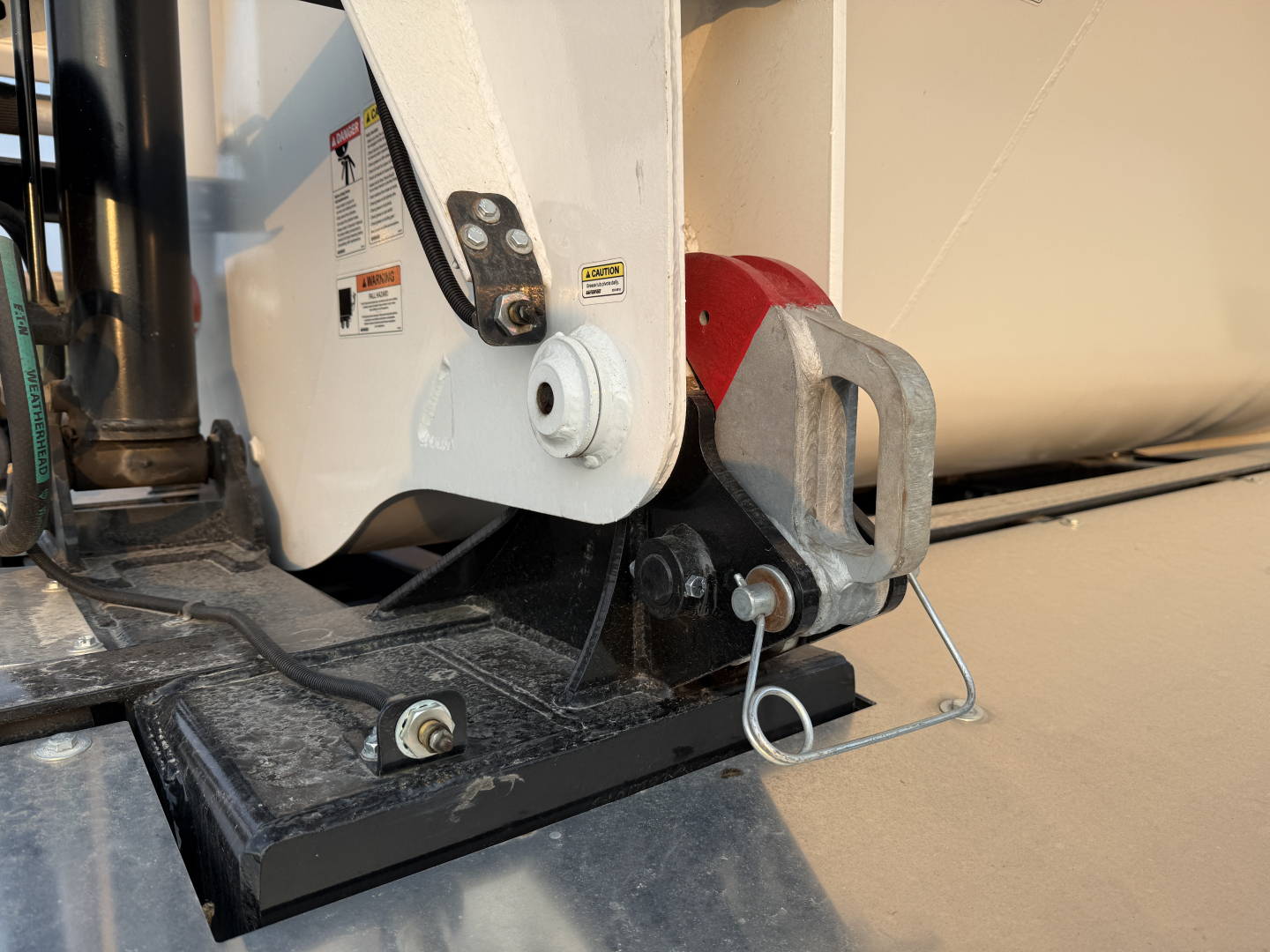 Trailer hitch and mount on Manac 42' Tri Axle dumping trailer showing hitch pin, safety chain, and mount bracket near black steel frame.