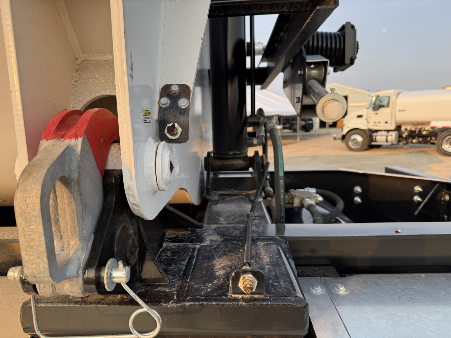 Manac 42' tri-axle trailer hitch area showing mounting bracket, hydraulic cylinder, and frame components.