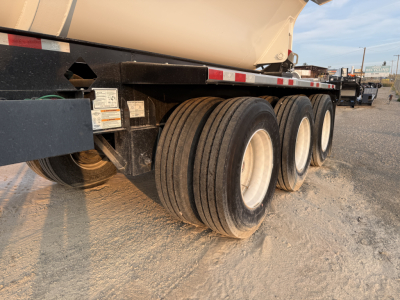 Manac 42' tri-axle dump trailer (new) showing triple axle wheels and side frame.