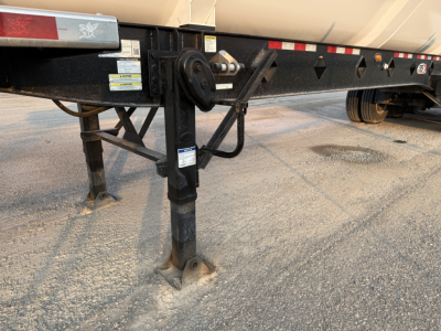 Manac 42' tri-axle trailer hitch leg and frame with safety chains and decals visible.