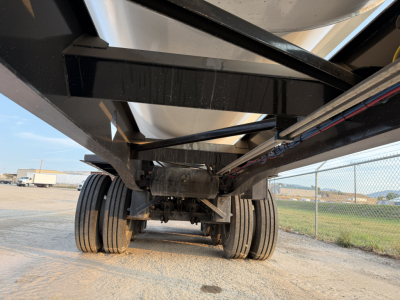 Manac 42' tri-axle trailer undercarriage with dual axles and multiple tires, view from rear undercarriage showing suspension and frame.