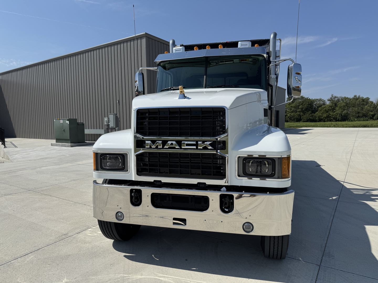 Front view of a 2026 Mack PI64 dump truck showing bold MACK grille, large chrome bumper, dual mirrors, and headlights.