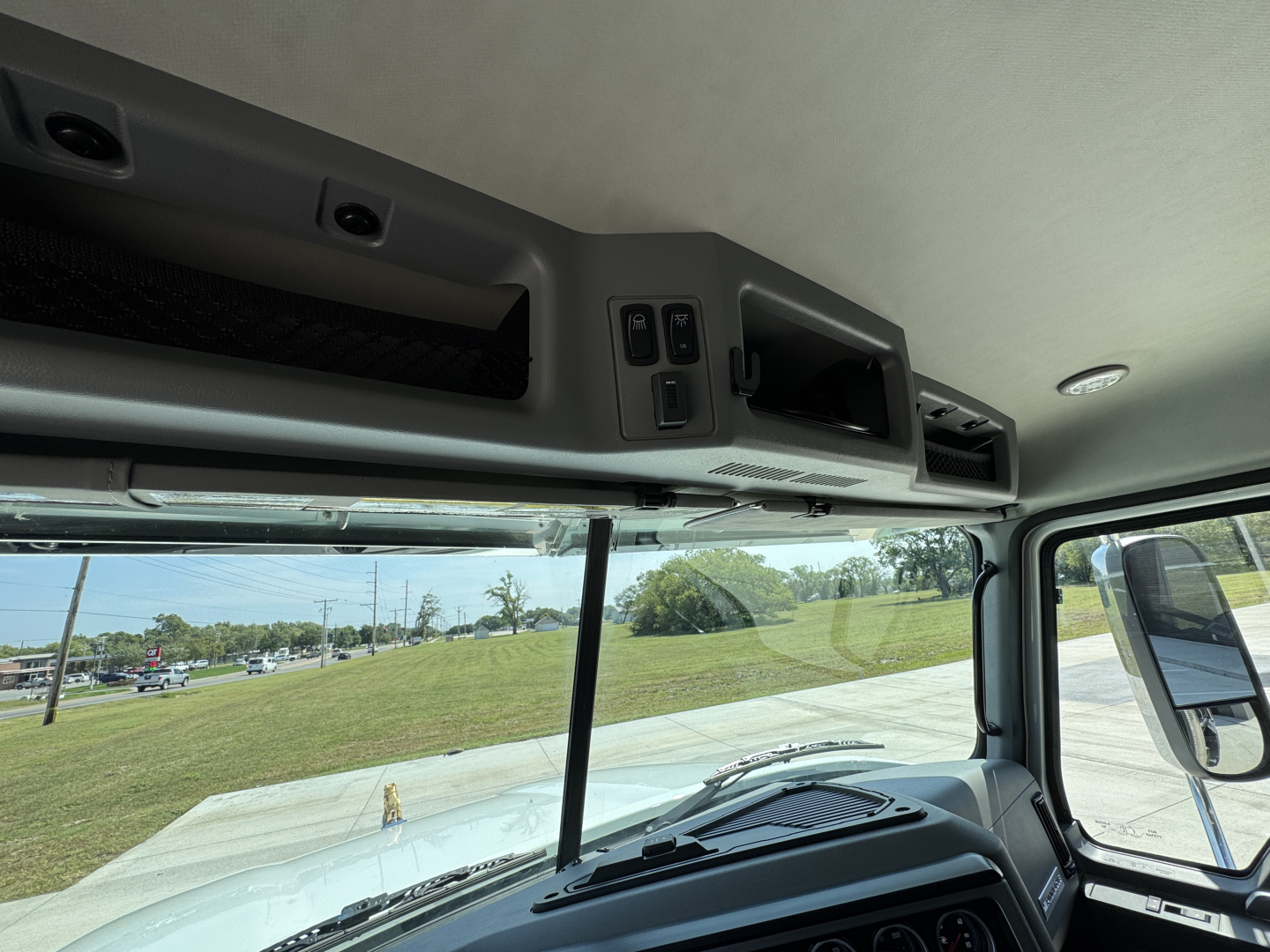 Mack PI64 cab interior showing overhead control panel and sun visor area.
