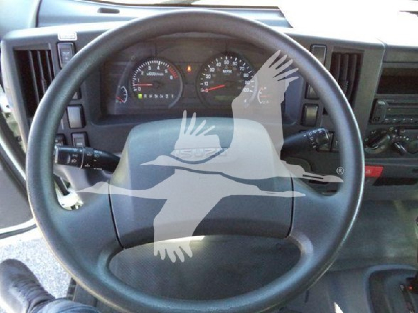 Dashboard and steering wheel view of a 2020 Isuzu NPR HD truck interior.