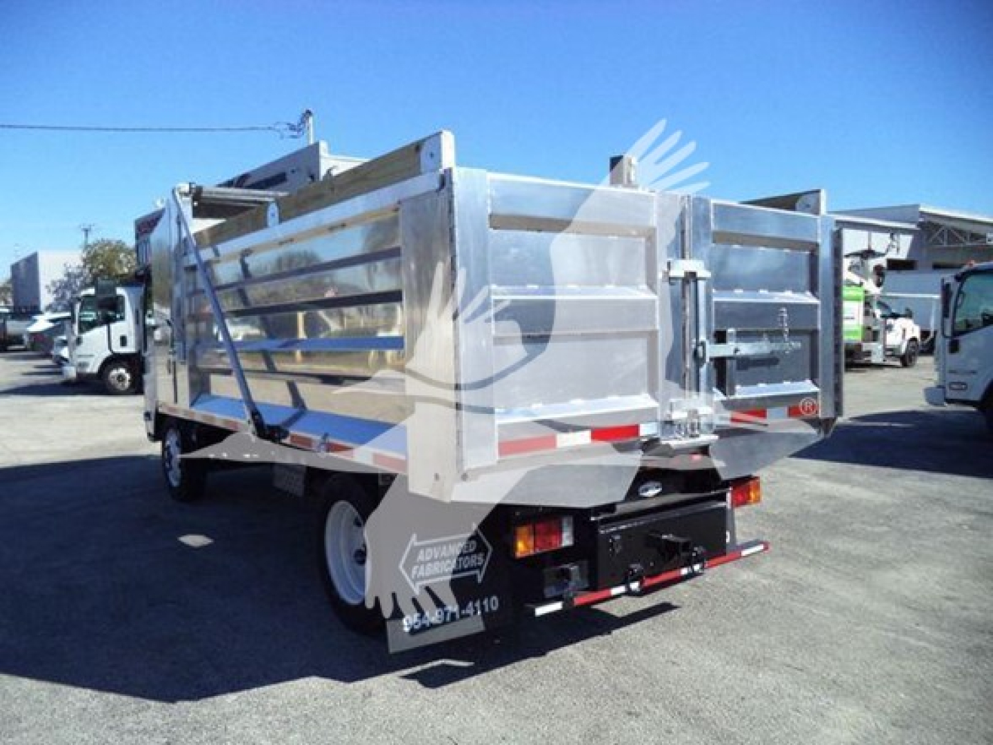 Isuzu NPR-HD dump truck rear view showing aluminum dump bed and taillights