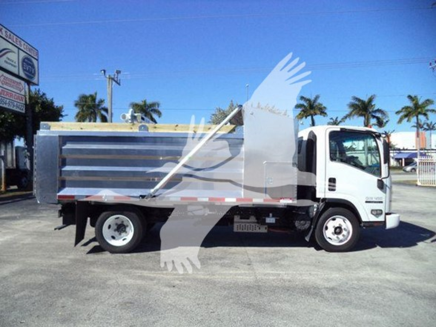 Isuzu NPR HD dump truck side view showing cargo bed and cab with white paint