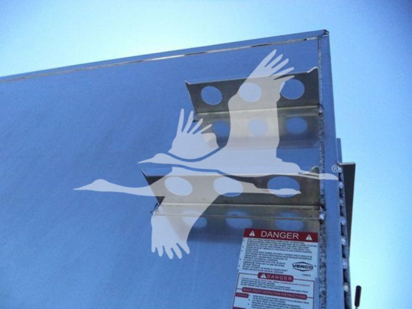 Isuzu NPR HD truck image showing a blue side panel with welded steps and a danger label sticker visible.
