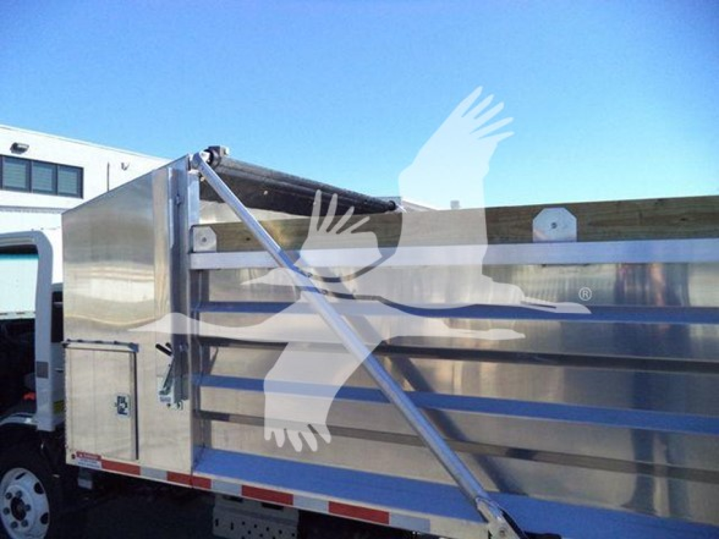 Isuzu NPR HD truck side view showing metal cargo body and reflective stripes.