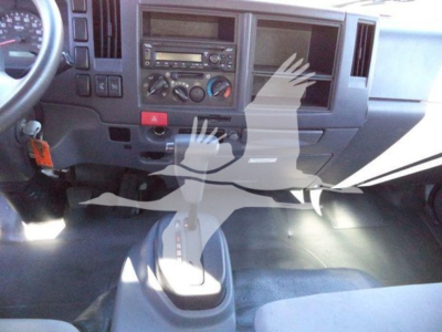 Dashboard view of a 2020 Isuzu NPR HD cab showing steering wheel, center console, climate controls, radio, and gear shifter.