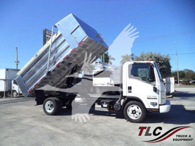 Isuzu NPR HD dump truck in service position with hauling bed raised, front cab and wheels visible, dealership lot background.