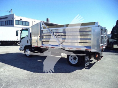 Isuzu NPR HD dump truck side view with metal dump bed and white cab, in a dealership lot.
