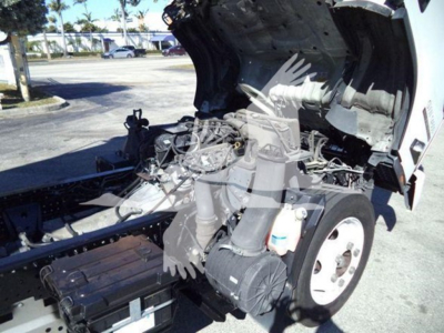 Isuzu NPR-HD truck engine bay with hood open showing engine components and front wheel.