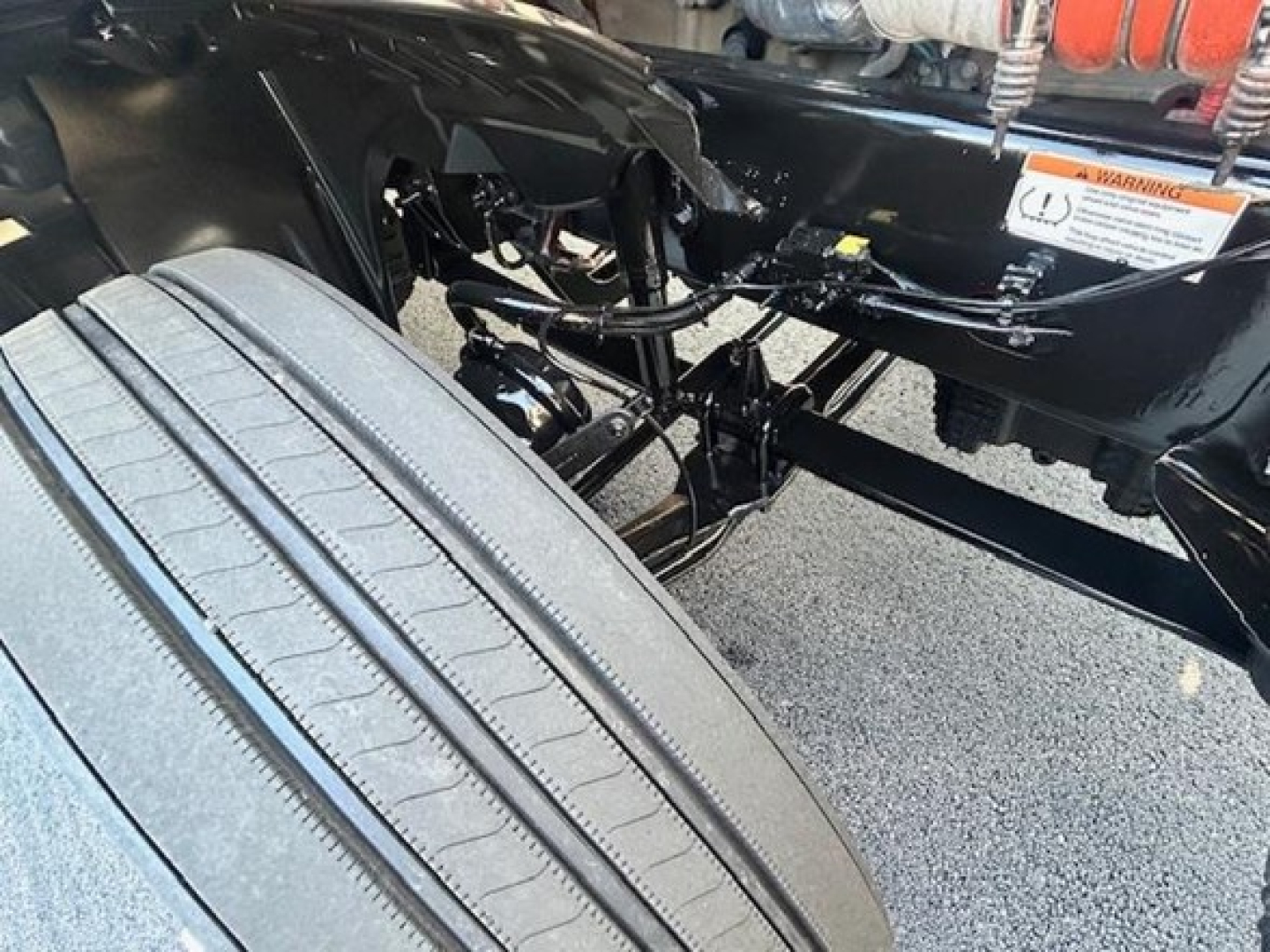 Freightliner Cascadia 126 chassis and front suspension visible with tire and undercarriage components.