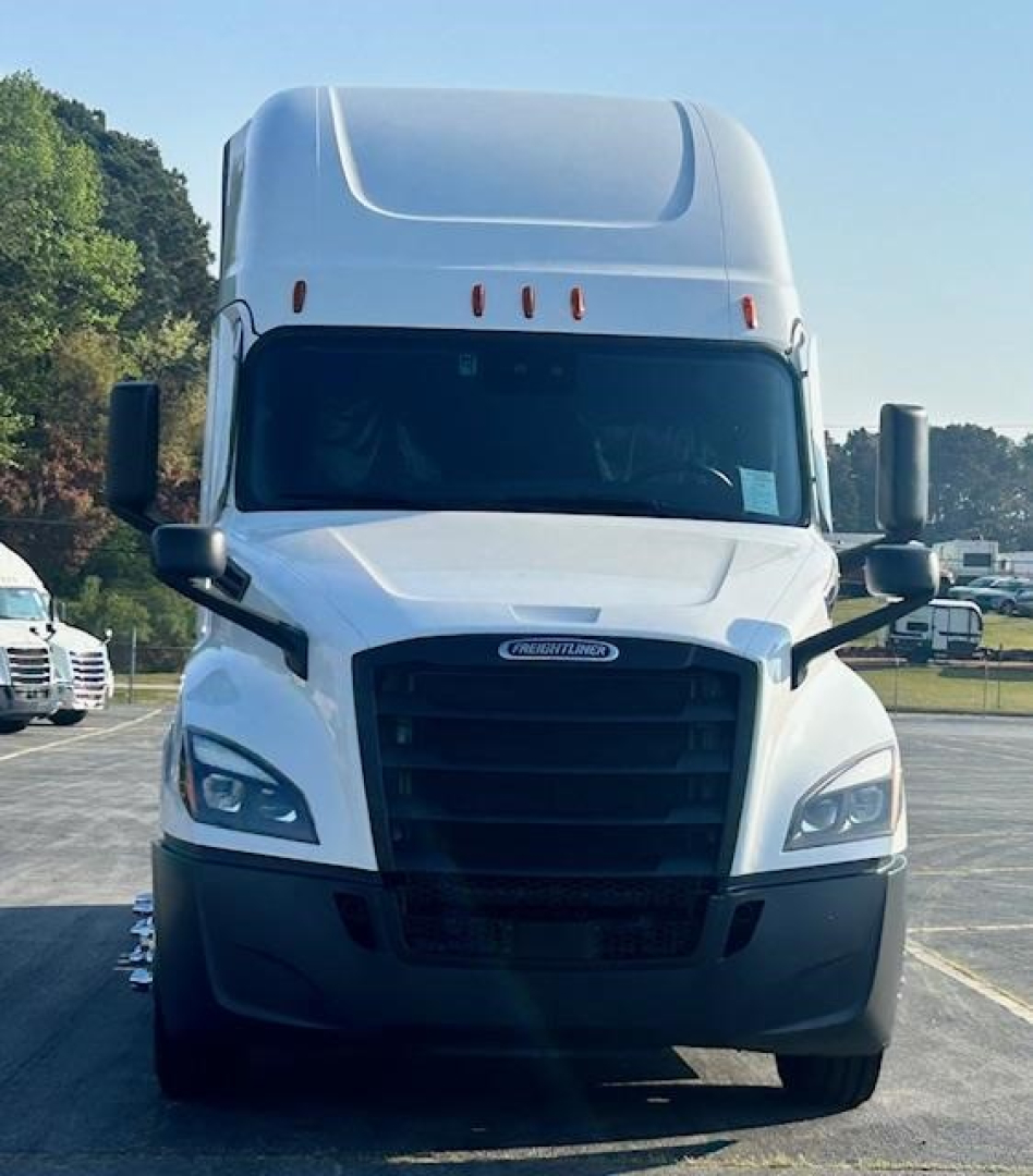 Freightliner Cascadia 126 truck front view showing grille, headlights, and white cab in a parking lot.