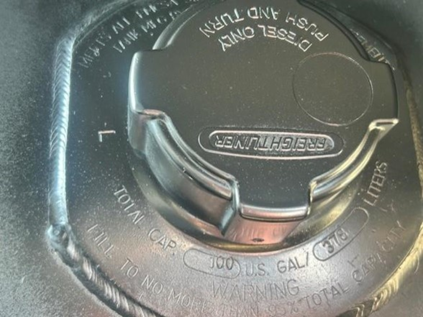 Fuel cap on Freightliner Cascadia 126 fuel tank showing 'Diesel Only' and cap outline with center latch.