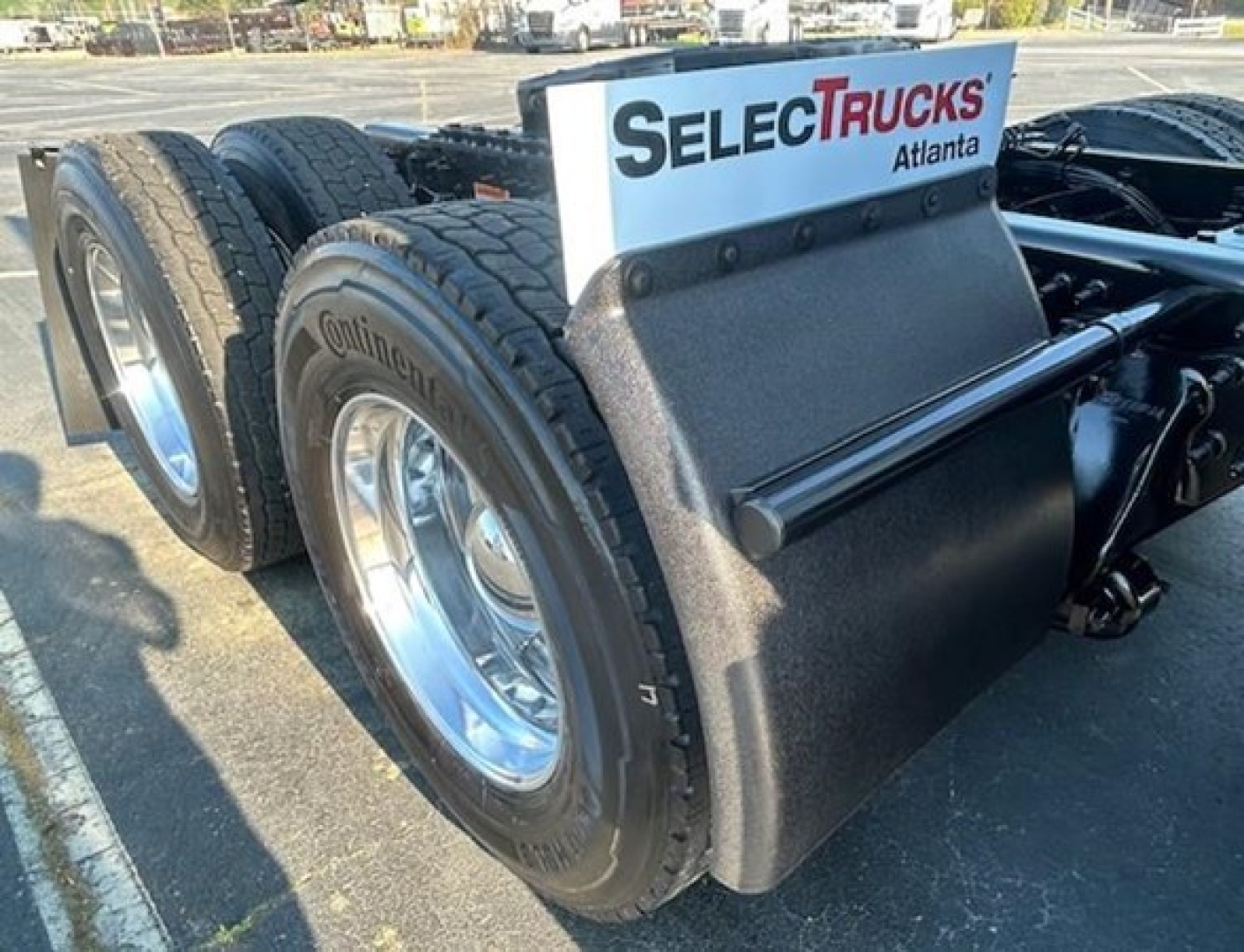 Freightliner Cascadia 126 rear dual tires and mudguard with SelecTrucks Atlanta sign on sleeper area.