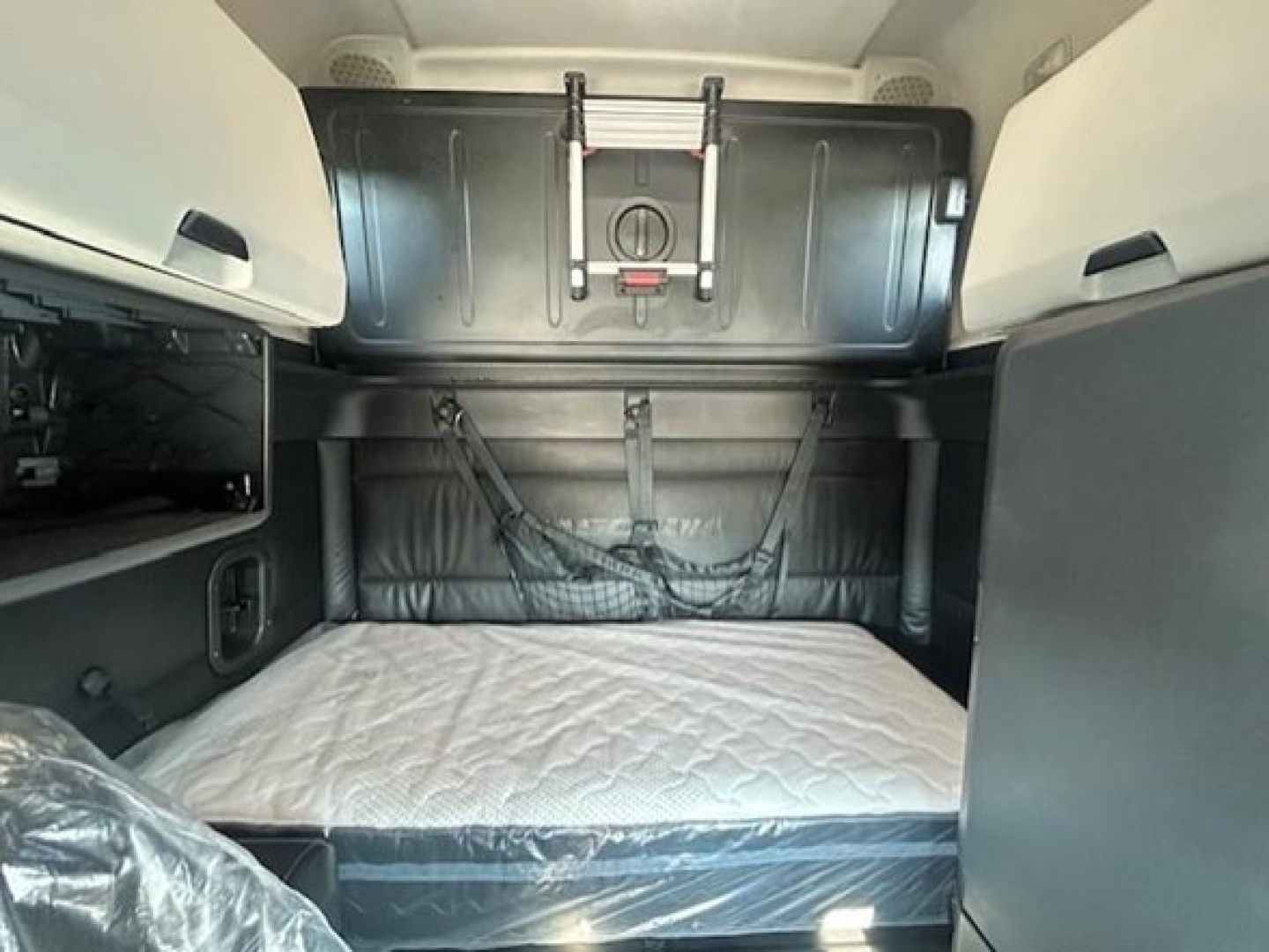 Freightliner Cascadia 126 sleeper cab interior showing bunk bed area with mattress and storage compartments
