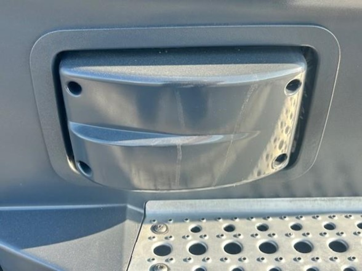 Freightliner Cascadia 126 cab step/entry area with molded steps and grab handle mount, showing textured plastic step cover and entry housing.