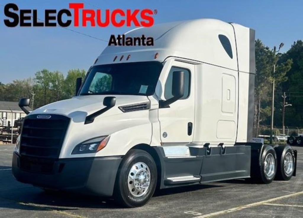 Truck image showing a white 2023 Freightliner Cascadia 126 sleeper tractor with dual rear axles and SelectTrucks Atlanta watermark.